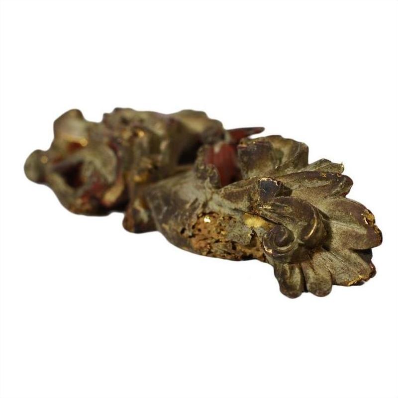 Pair of antique Chinese wooden temple carvings with ornate floral and leaf designs, close-up from below.