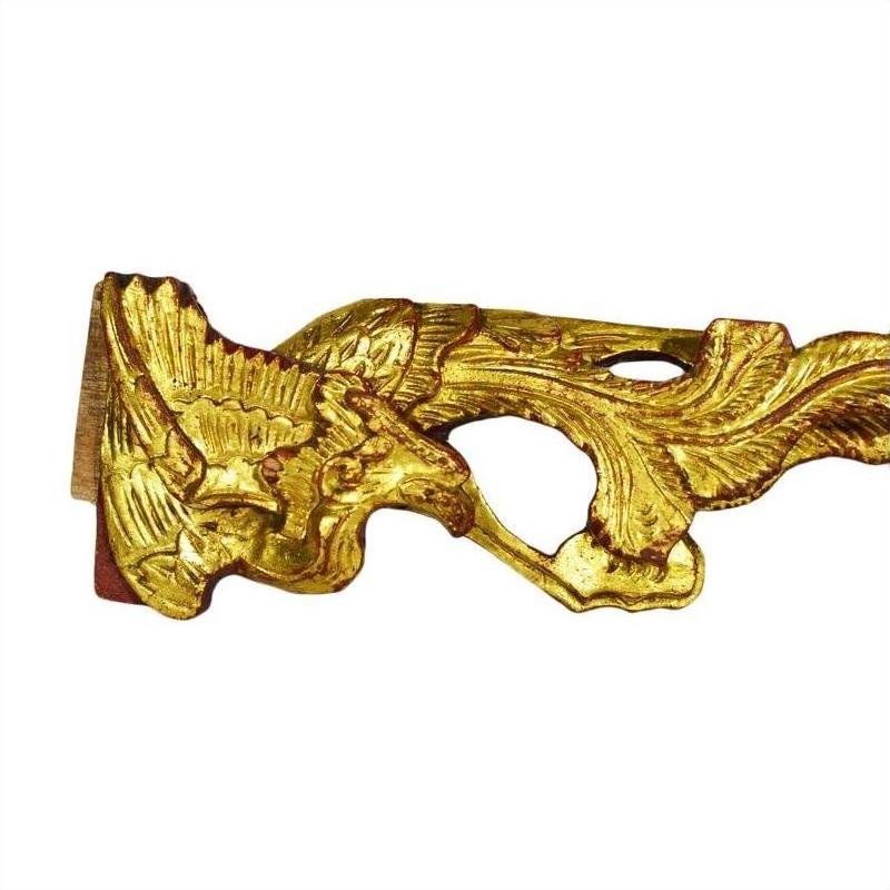 Ornate gold eagle carvings, antique Chinese temple art, close-up on plain white background.