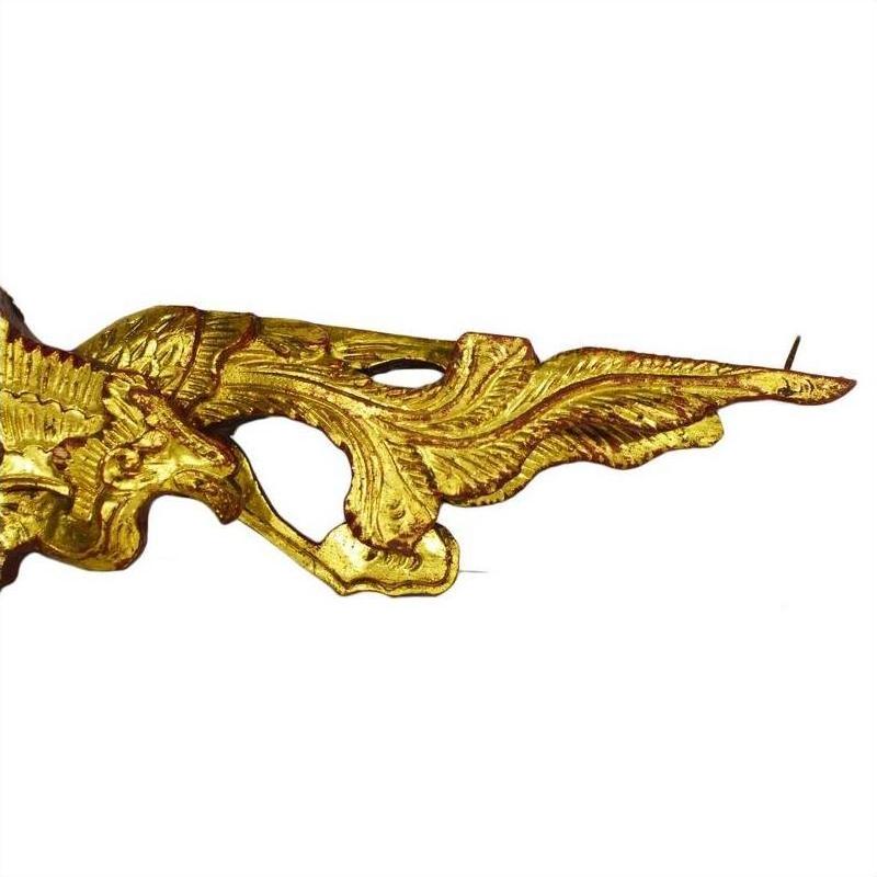 Gold carved wood Chinese temple figures with feathered wing-like design on white background, close-up.