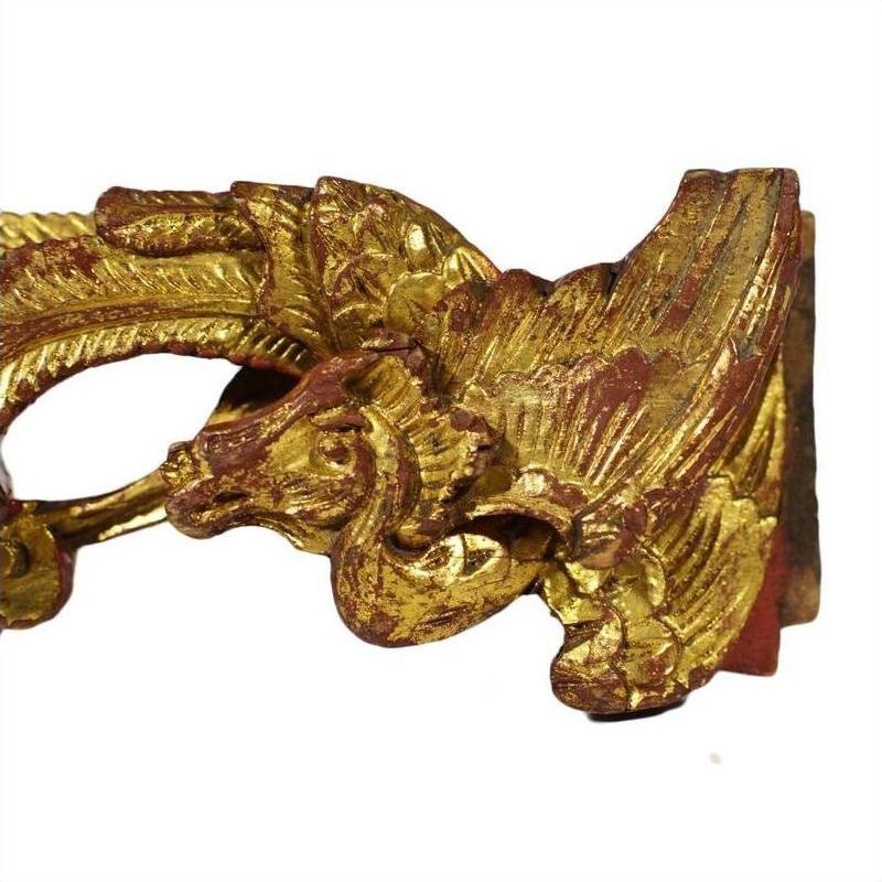 Gold-painted wood carvings, pair of winged mythical creatures with feather and scale details, antique style.