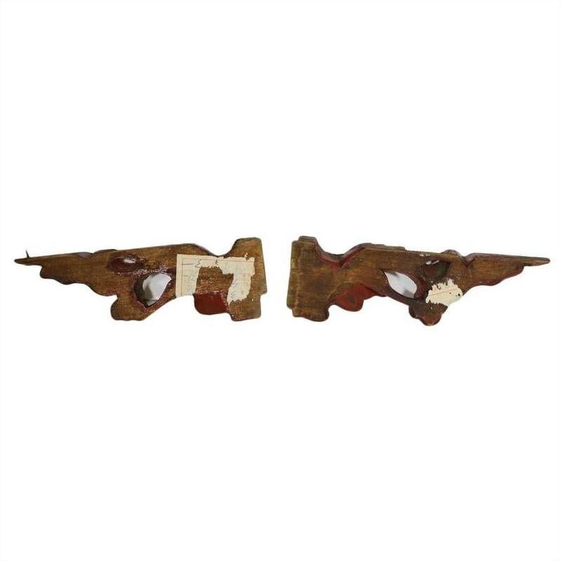 Red and white wood temple carvings pair with faded paint, irregular shapes, and exposed areas visible.