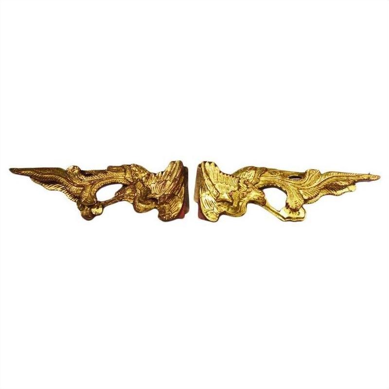Gold wood antique Chinese temple carvings of winged creatures on a white background, close-up view.