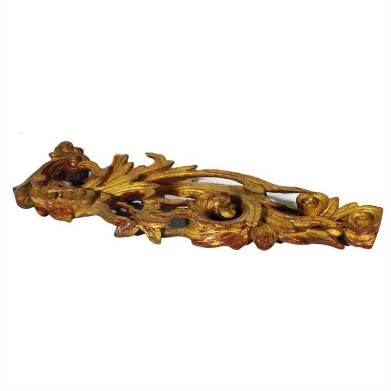 Gold-painted wood Chinese temple carvings pair with intricate leaf and floral patterns on white background, close-up.