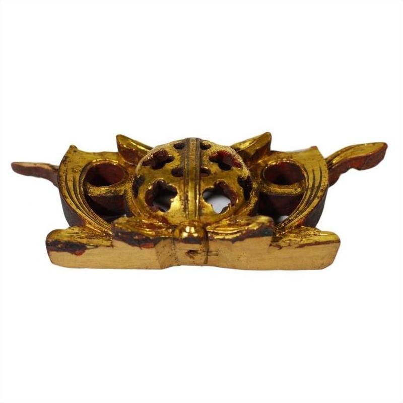 Close-up of antique Chinese temple carvings with spherical perforated wood centers and wing-like accents.