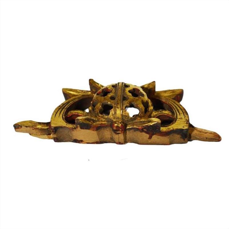 Close-up of golden antique Chinese temple carvings, ornate with pointed ends and round filigree centers.