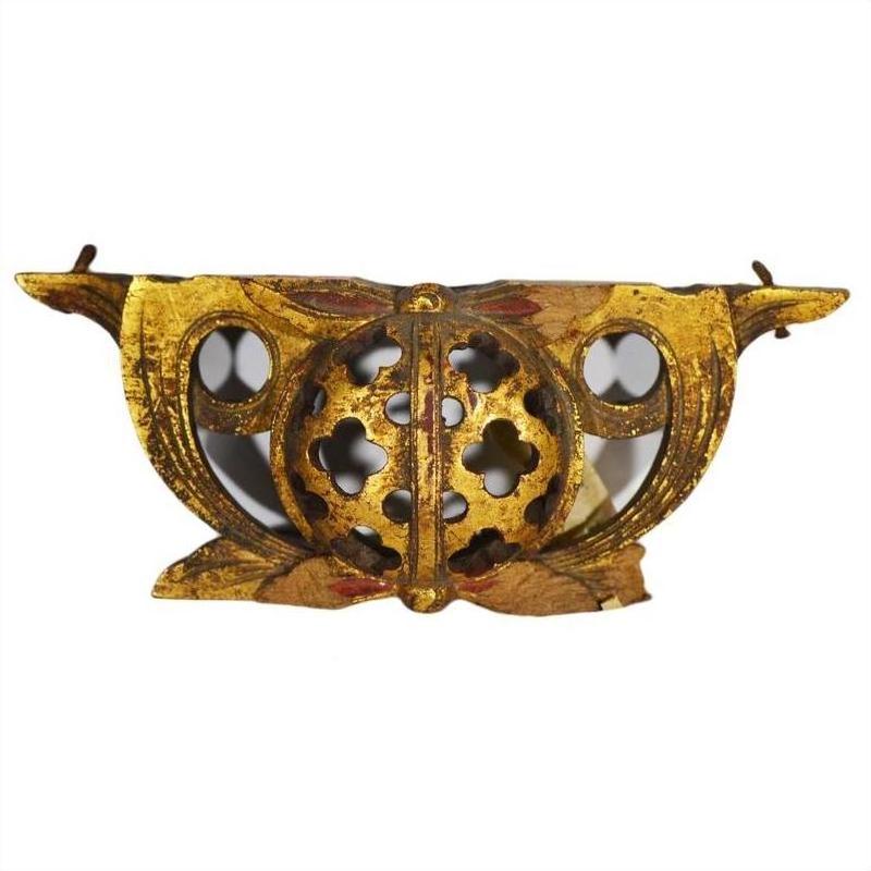 Gold-painted antique Chinese wood temple carvings with floral cutouts and ornate wing-like details, close-up view.
