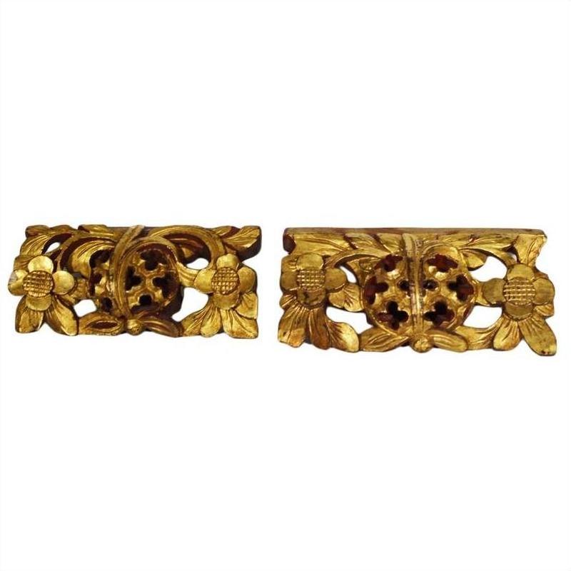 Brown wooden antique Chinese temple carvings with floral and leaf patterns, side by side on a white background.