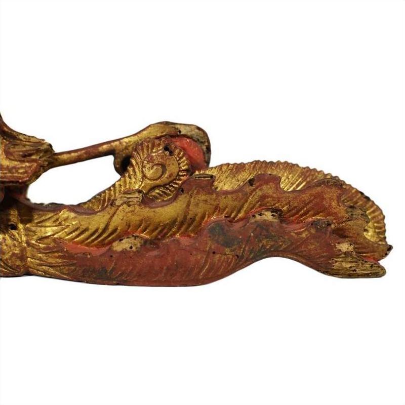 Close-up of ornate gold and red wood Chinese temple carvings pair with intricate curved edges.
