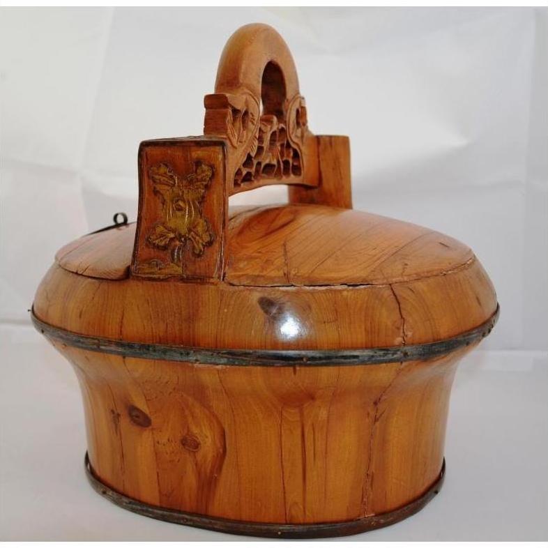Brown wooden round box with lid and carved handle, antique Chinese wedding basket style, close-up.