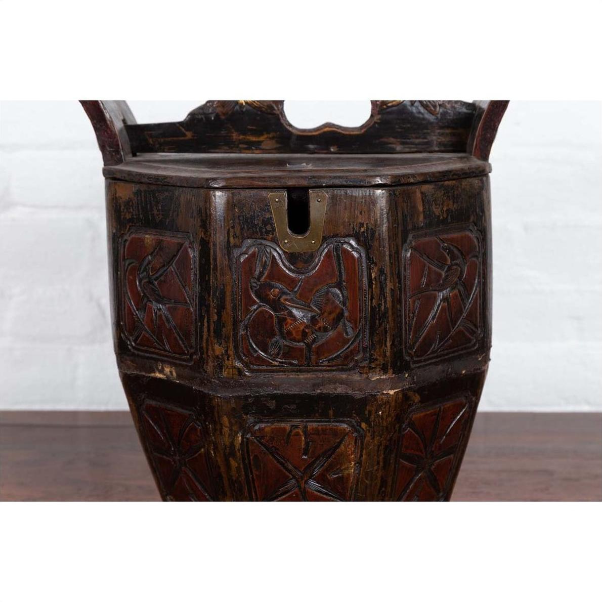 Close-up of a brown antique Chinese wedding box with carved handle, animal and foliage motifs, wood material.