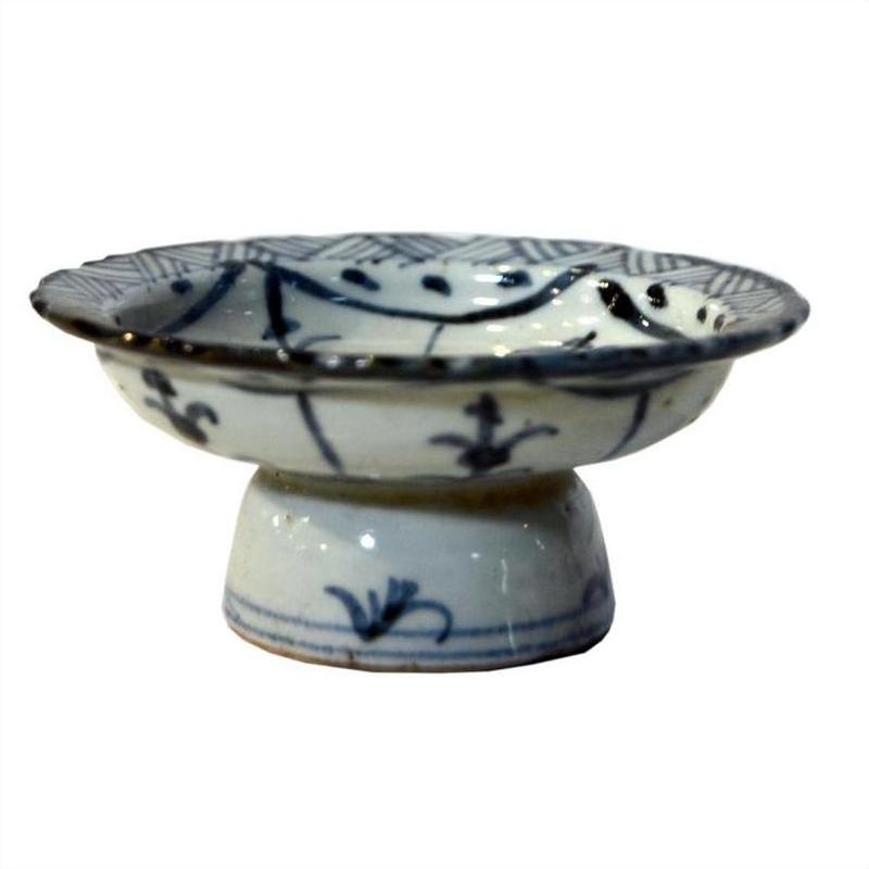 Close-up of a white and blue porcelain footed rice bowl with floral patterns, vintage style, on a white background.