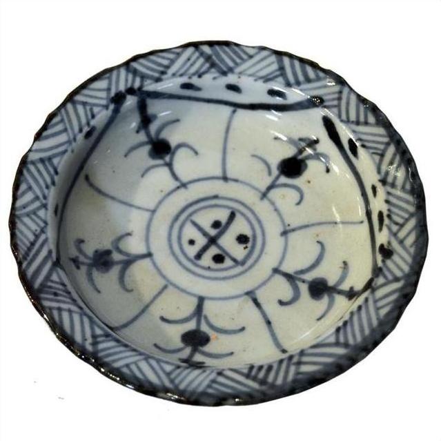 Close-up of antique Chinese white and blue ceramic footed rice bowl with blue floral motifs on the exterior.