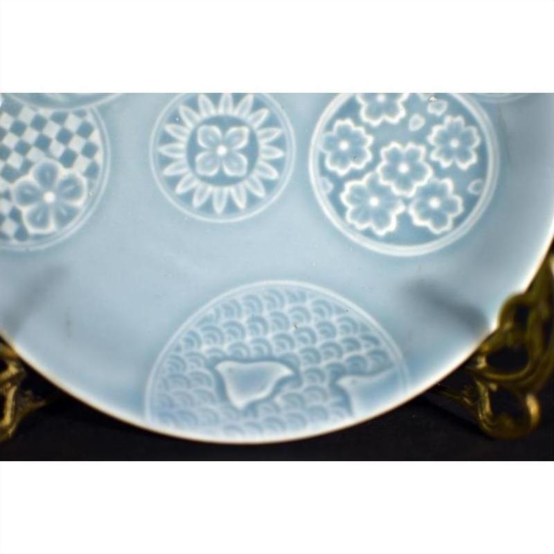 Close-up of a white embossed Chinese porcelain plate with circular floral and geometric patterns.