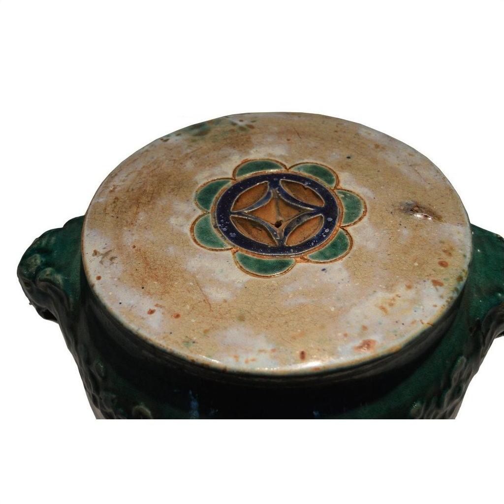 Green and brown glazed ceramic Annamese garden seat or side table with floral lid, top view.