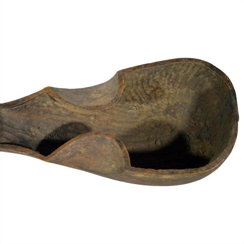 Close-up of a weathered wood hand-carved antique Indian lute or sitar with rustic, worn details.