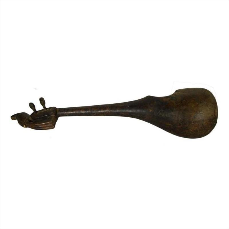 Brown hand-carved wooden Indian lute or sitar with rounded body and handle shaped like a hand with three raised fingers.