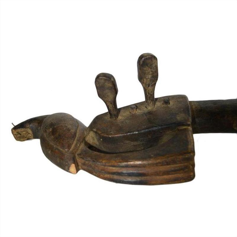 Brown hand carved wooden Indian sitar with two vertical projections against a plain white background.