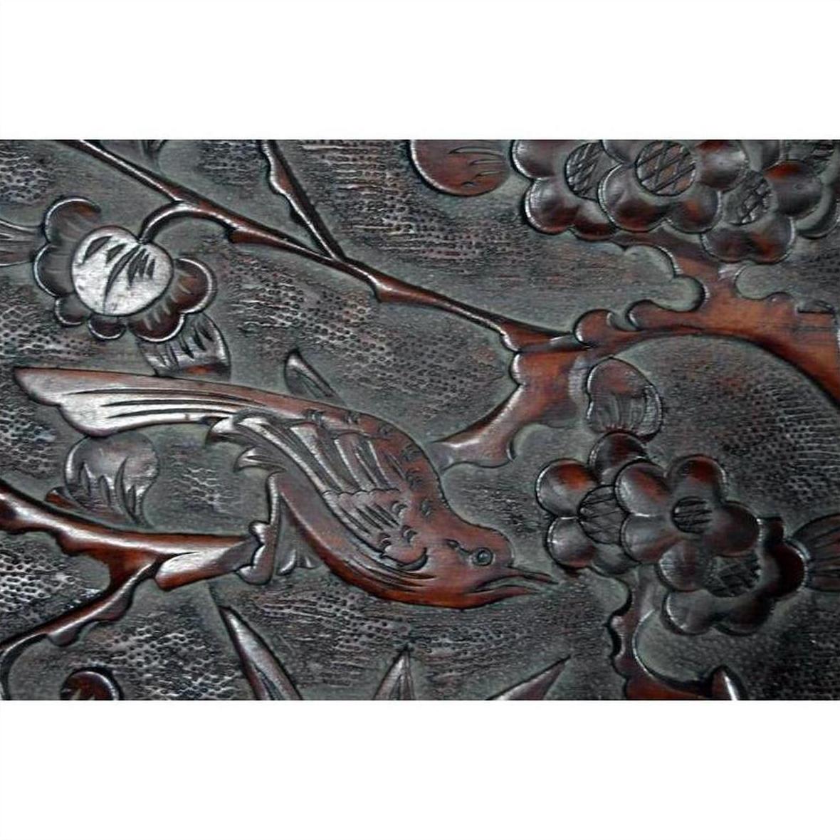 Close-up of antique hand-carved lacquered rosewood wall plaque with bird, branch, flowers, and detailed foliage.
