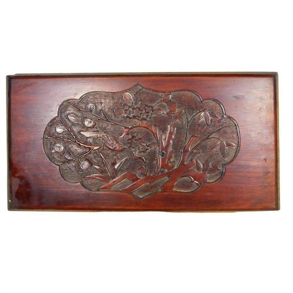 Reddish-brown lacquered rosewood wall plaque with hand-carved 19th-century floral and leaf details, close-up view.