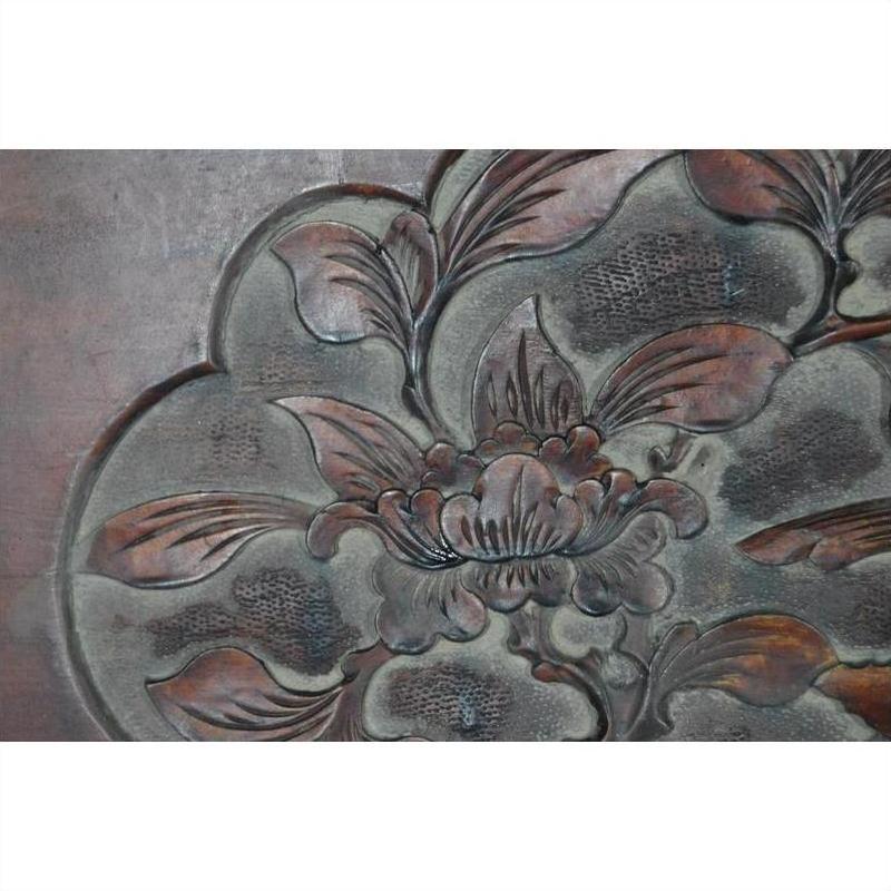 Close-up of lacquered rosewood wall plaque with hand-carved floral and leaf designs, 19th century China.
