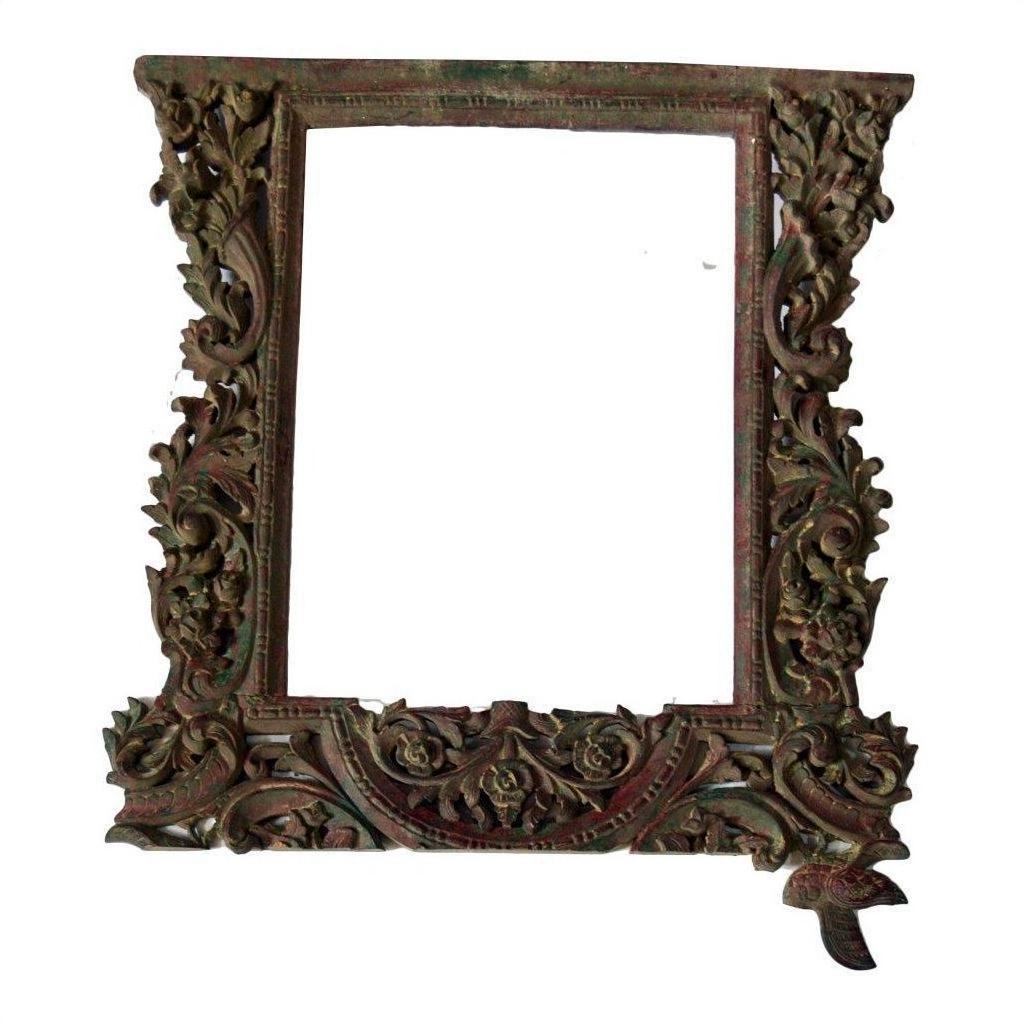 Brown wood hand-carved mirror frame with intricate floral carvings and small bird accent, close-up view.