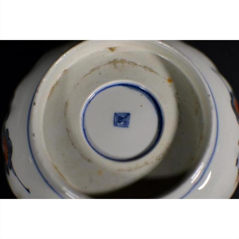 Close-up of white ceramic antique Asian bowl with blue square mark and stains in the center.