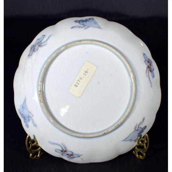 White ceramic plate underside close-up with hand painted details and label reading BTR.18.15 collectible.