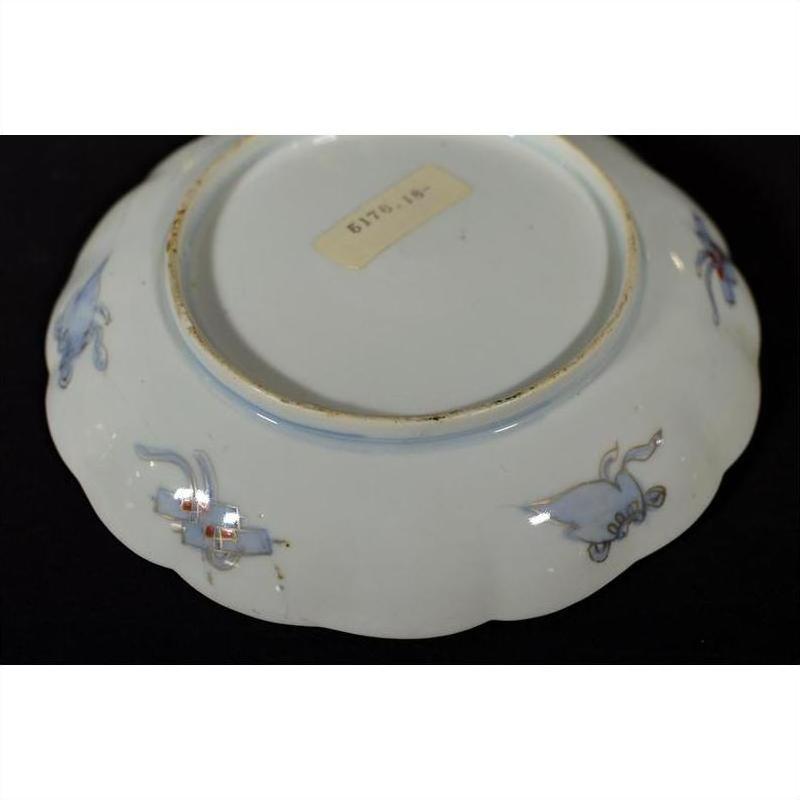 White ceramic plate underside with hand painted floral designs, label visible, close-up.