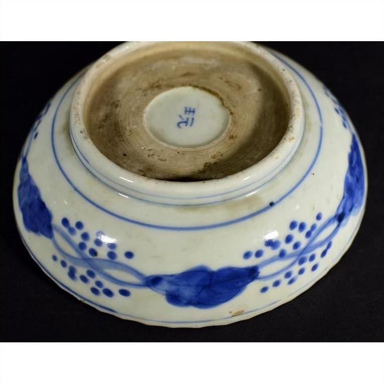 Blue porcelain Chinese bowl with hand-painted blue floral designs and a maker's mark on its unglazed base.
