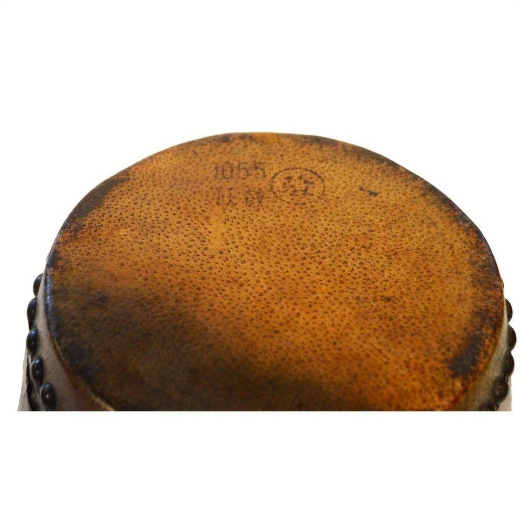 Close-up of a round brown painted antique Chinese drum surface with faint numbers and a circular stamp.