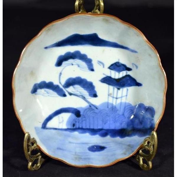 White and multicolor hand painted Chinese porcelain plate with trees, pavilion, mountain, and water on metal stand.