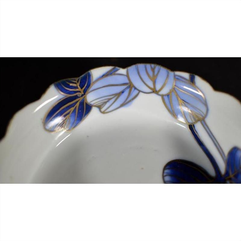 Close-up of four blue and gold hand painted Japanese Imari porcelain bowls with leaf designs.