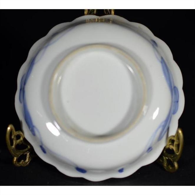 Blue and white porcelain bowls, hand-painted, set of 4 on gold stand, black background.