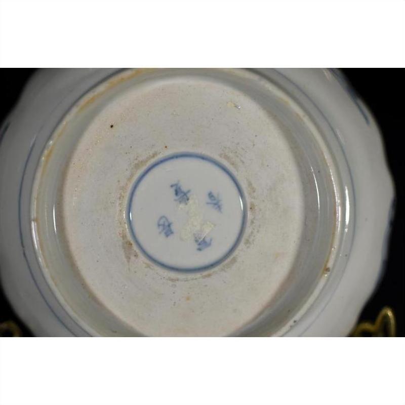 Close-up of blue and white porcelain bowl bottom with hand painted blue characters and circular blue border.