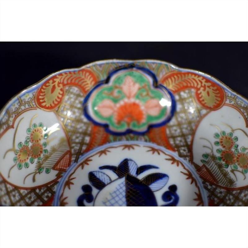 Close-up of red, blue, green, and gold floral Japanese Imari porcelain bowl, hand painted antique.