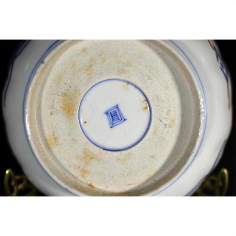 Close-up of blue and brown base on porcelain bowl with square mark and patina.
