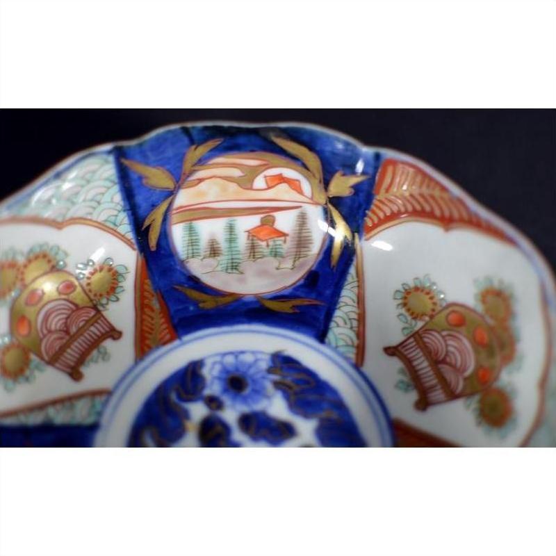 Close-up of a multicolor porcelain Japanese Imari bowl with hand painted intricate patterns and a scenic center design.
