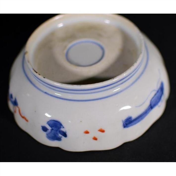 Blue and red porcelain bowl, hand painted, upside down on black surface.