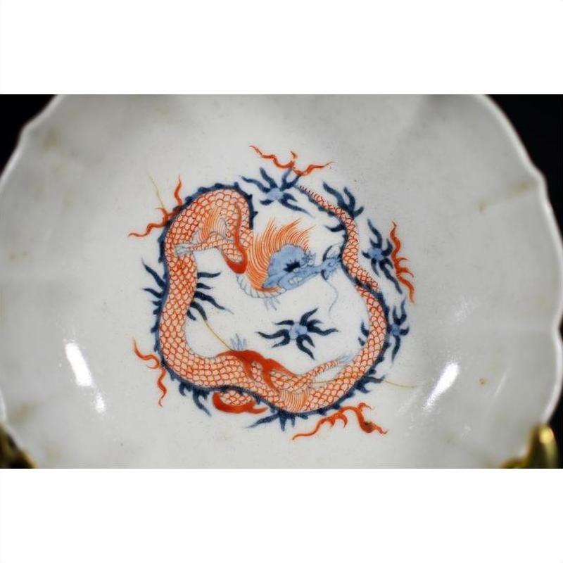 Set of four antique Japanese Imari porcelain bowls with hand-painted red and blue dragons and blue flames, on table.