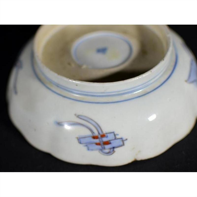 Close-up of blue and red porcelain bowl underside, hand painted, showing Japanese Imari design.