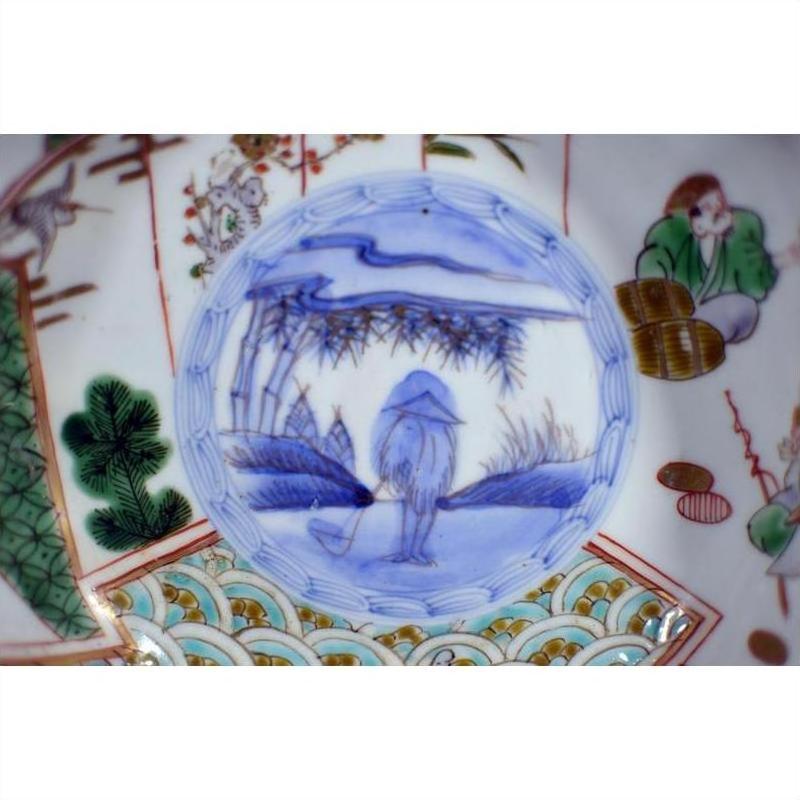Blue and white porcelain Japanese Imari bowl with hand painted landscape, figure in hat, and vibrant patterns.