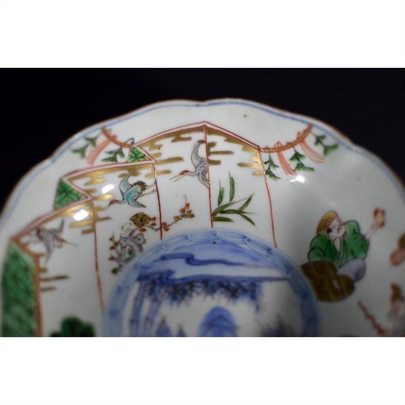 Close-up of a colorful hand painted Japanese Imari porcelain bowl with figures, birds, and foliage decoration.