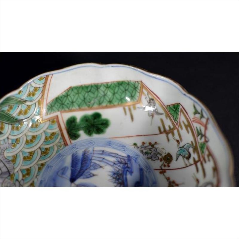 Close-up of a green, blue, and gold porcelain bowl with painted patterns, antique Japanese Imari style.
