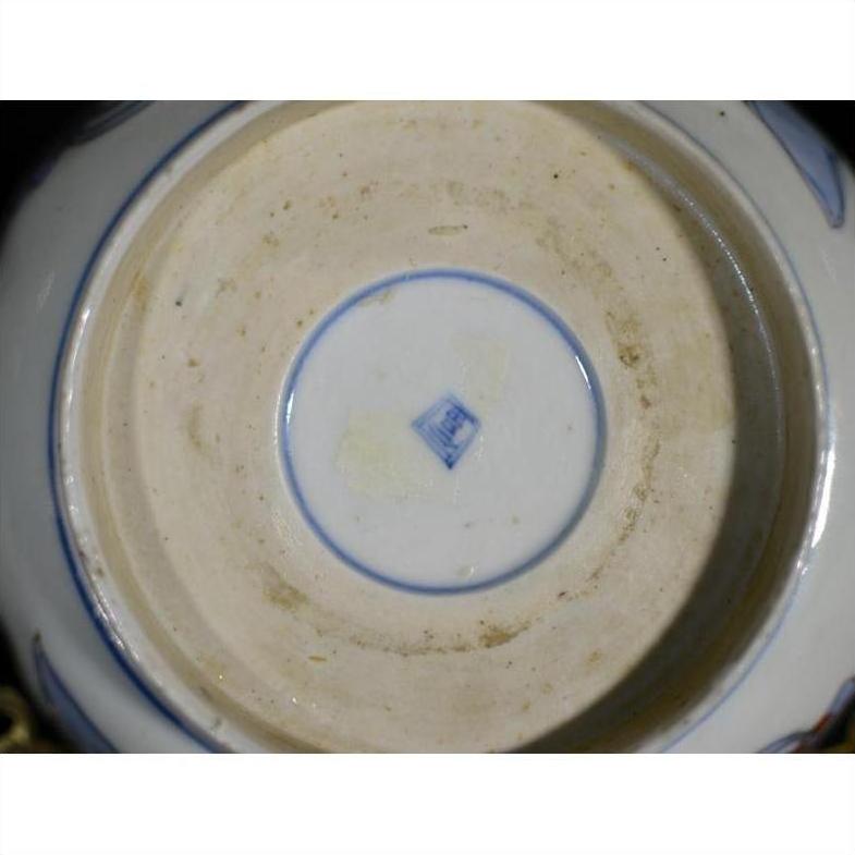 Blue and white porcelain bowl underside with blue square mark and light base staining, close-up.