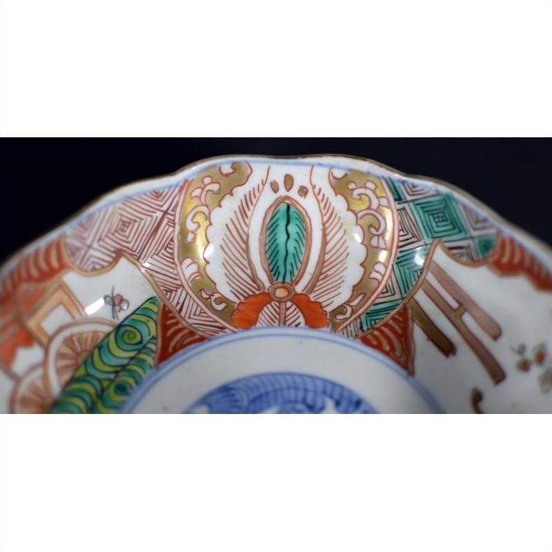 Close-up of a red, green, and gold hand painted porcelain Japanese Imari bowl with antique patterns.
