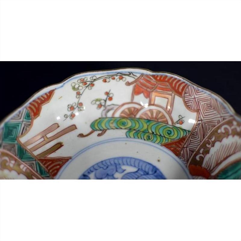 Close-up of a multicolor porcelain Japanese Imari bowl with hand painted floral patterns and intricate rim design.