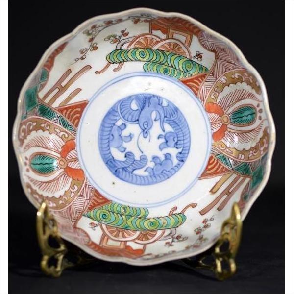 Close-up of blue, red, and green hand painted Japanese Imari porcelain bowl with serpent design.
