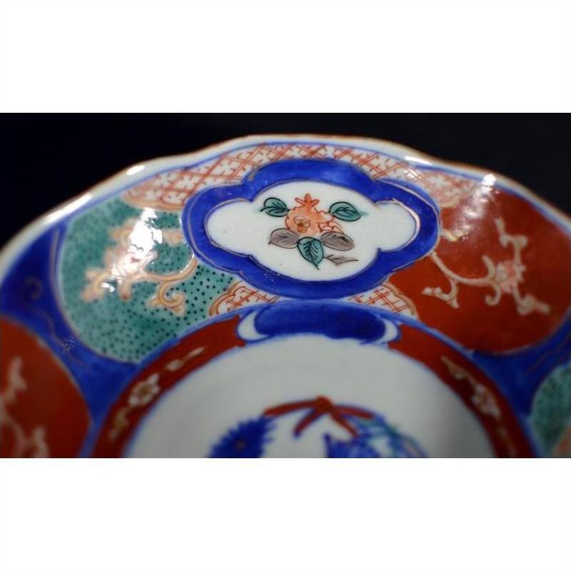 Close-up of four antique hand-painted Imari porcelain bowls with vivid floral and geometric patterns.