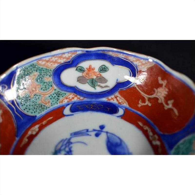 Close-up of four ceramic bowls with red, blue, and green floral rim patterns, hand-painted in antique style.