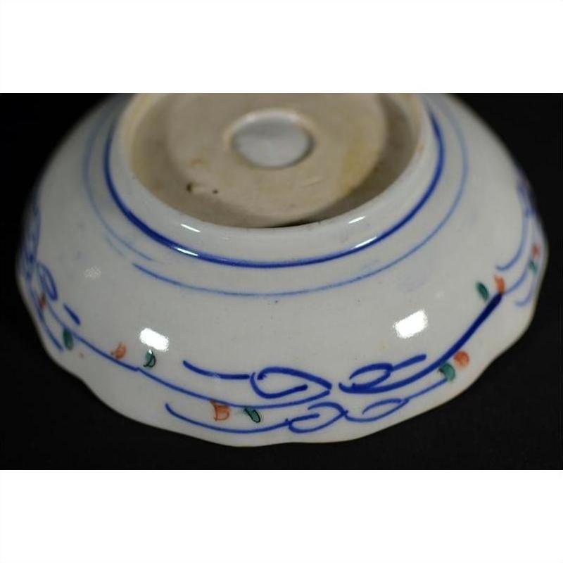 Blue and orange-green porcelain bowls set of four, hand-painted with wavy lines and floral accents near base.